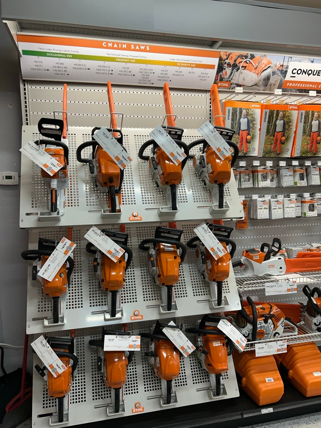 STIHL chainsaws on a tiered wall display with model and price tags