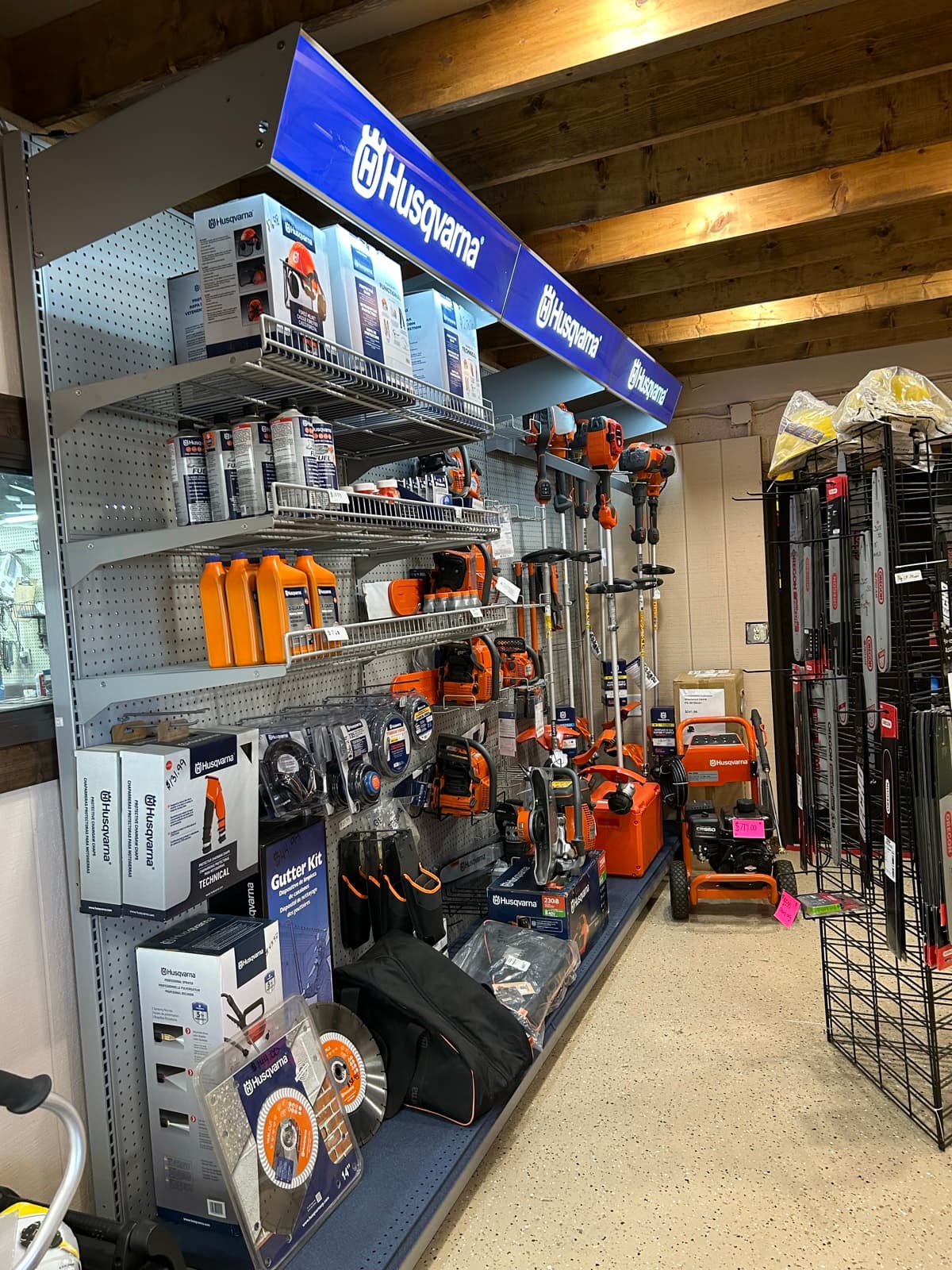 Husqvarna power equipment display table with branded chainsaws and boxed inventory