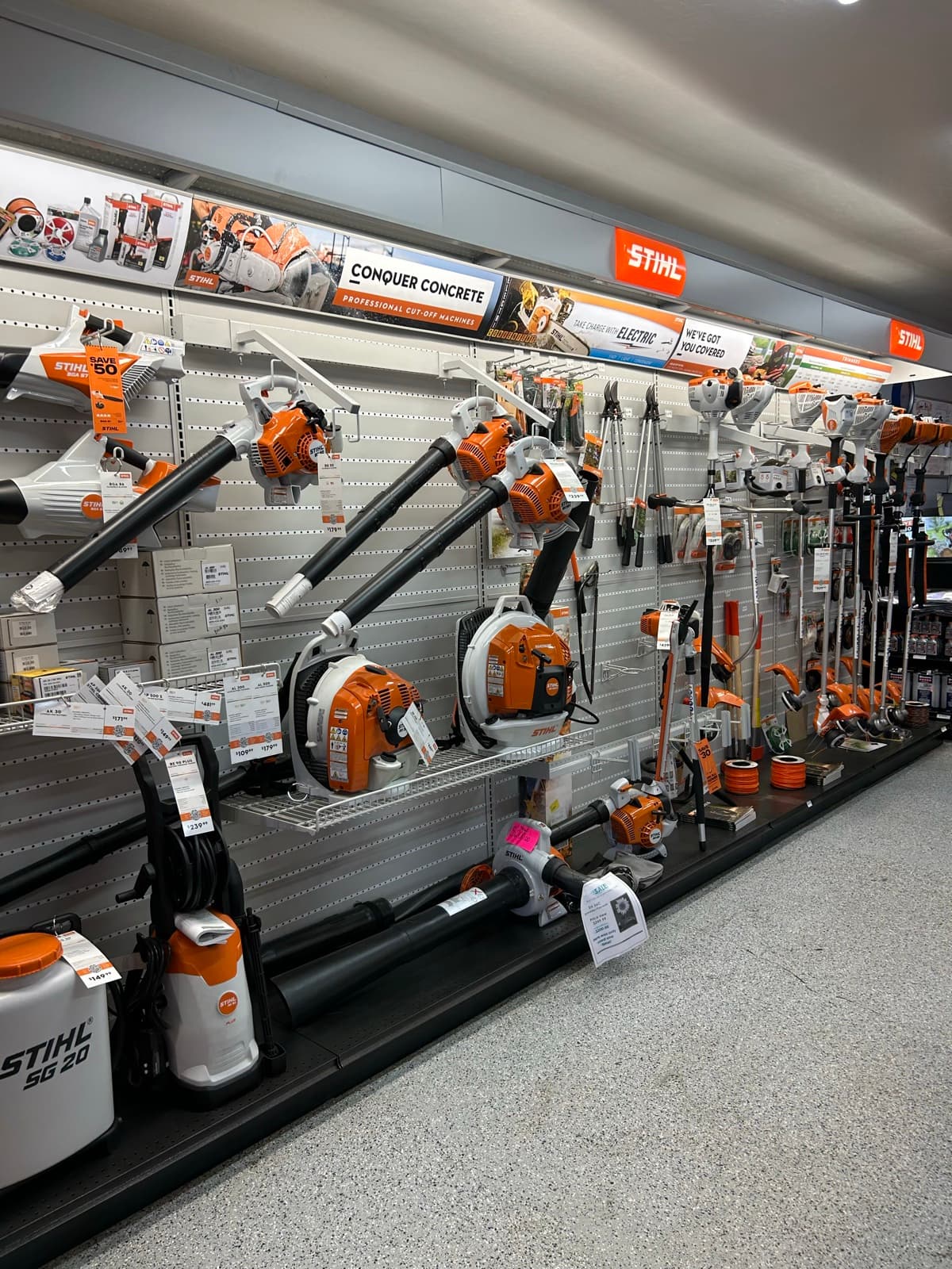 Row of STIHL string trimmers and leaf blowers mounted on slatwall display